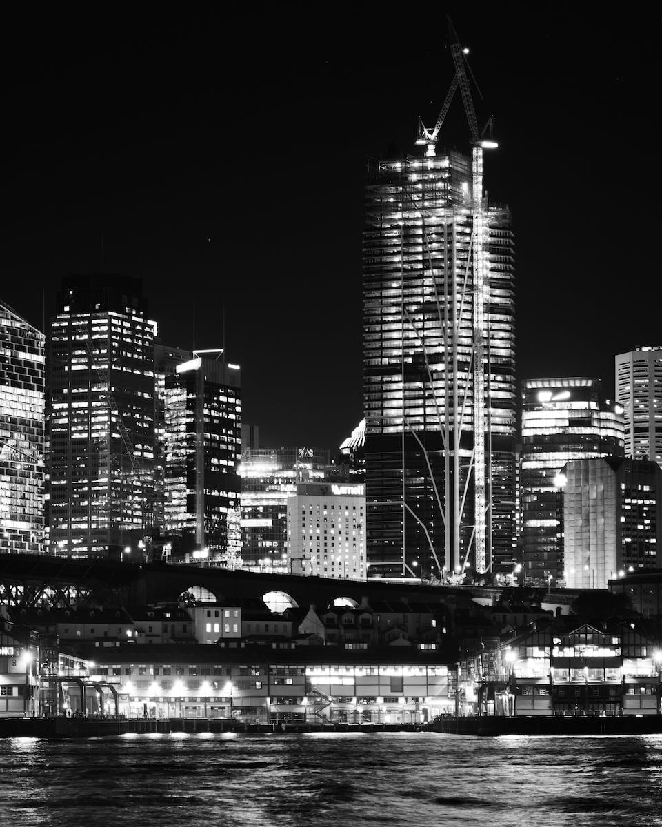 Grayscale Photo of City Buildings at Night