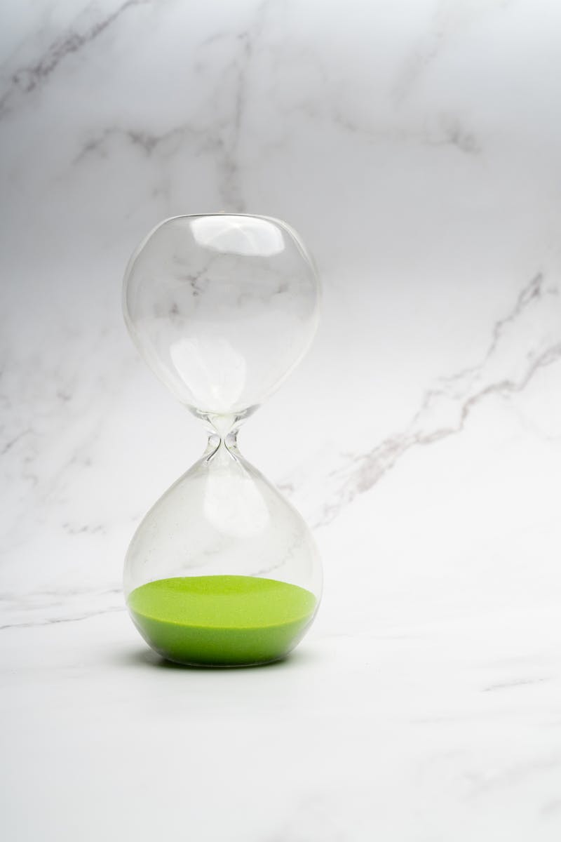 Clear Hourglass on White Marble Surface