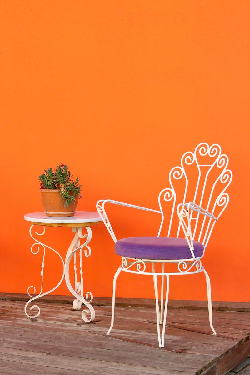 Chair and Table with Plant near Orange Wall