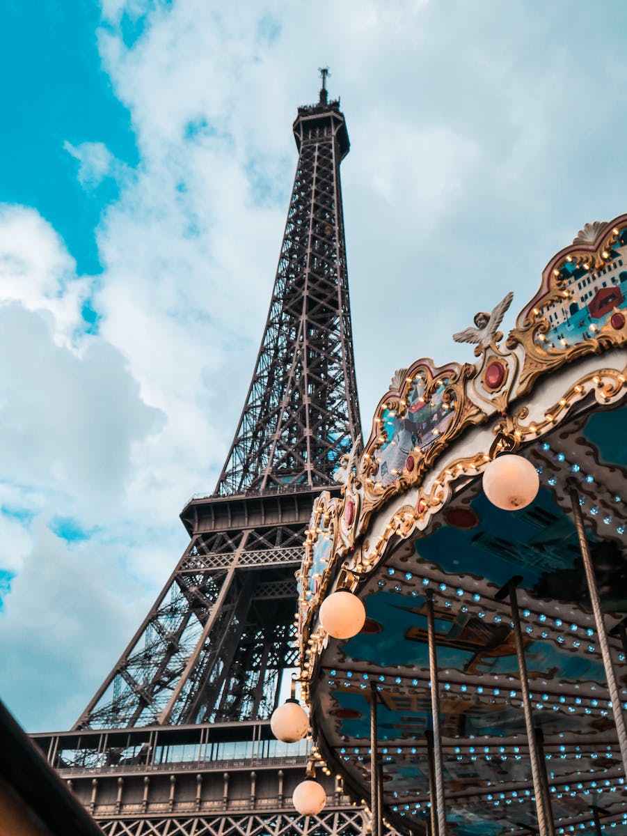 Low angle photography of eiffel tower and carousel