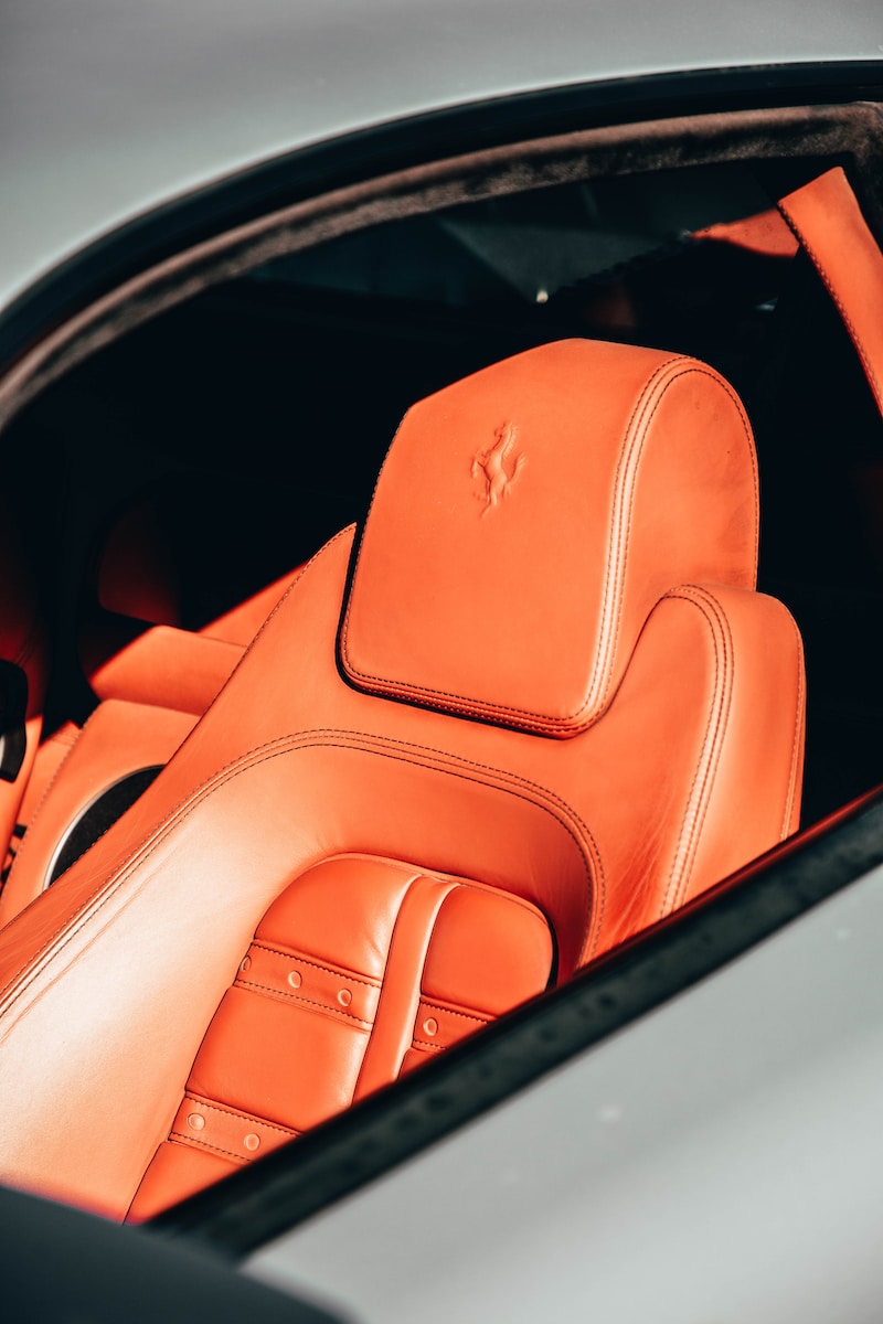 the interior of a sports car with orange leather