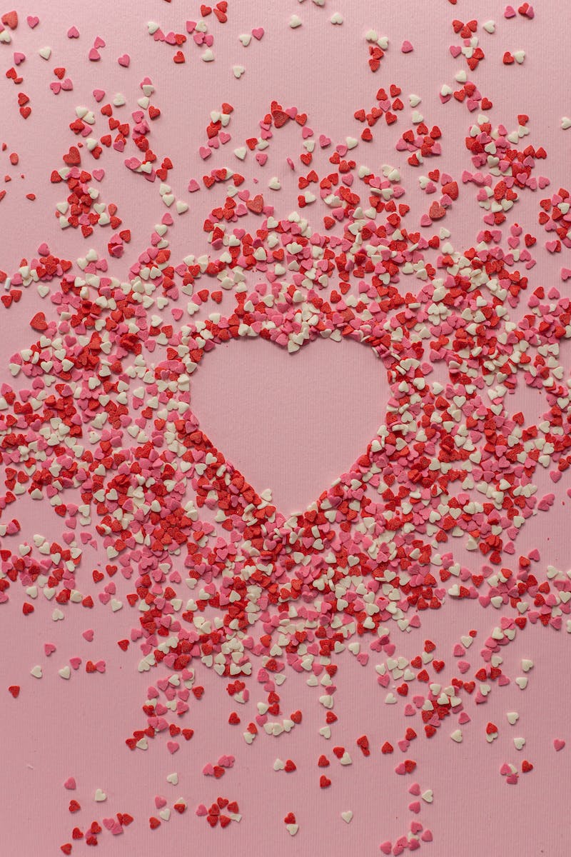 Paper hearts scattered on pink background