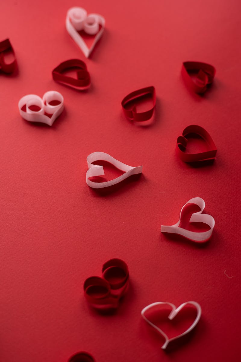 Small paper hearts for Valentines Day on red background