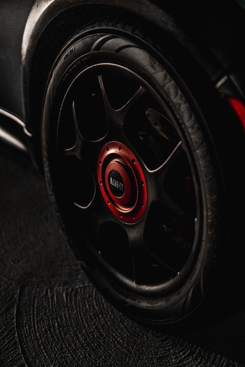 black and red multi-spoke car wheel with tire