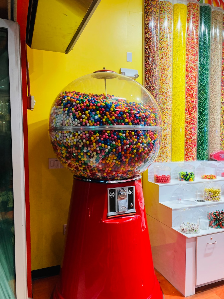 a large gummy machine sitting in front of a yellow wall