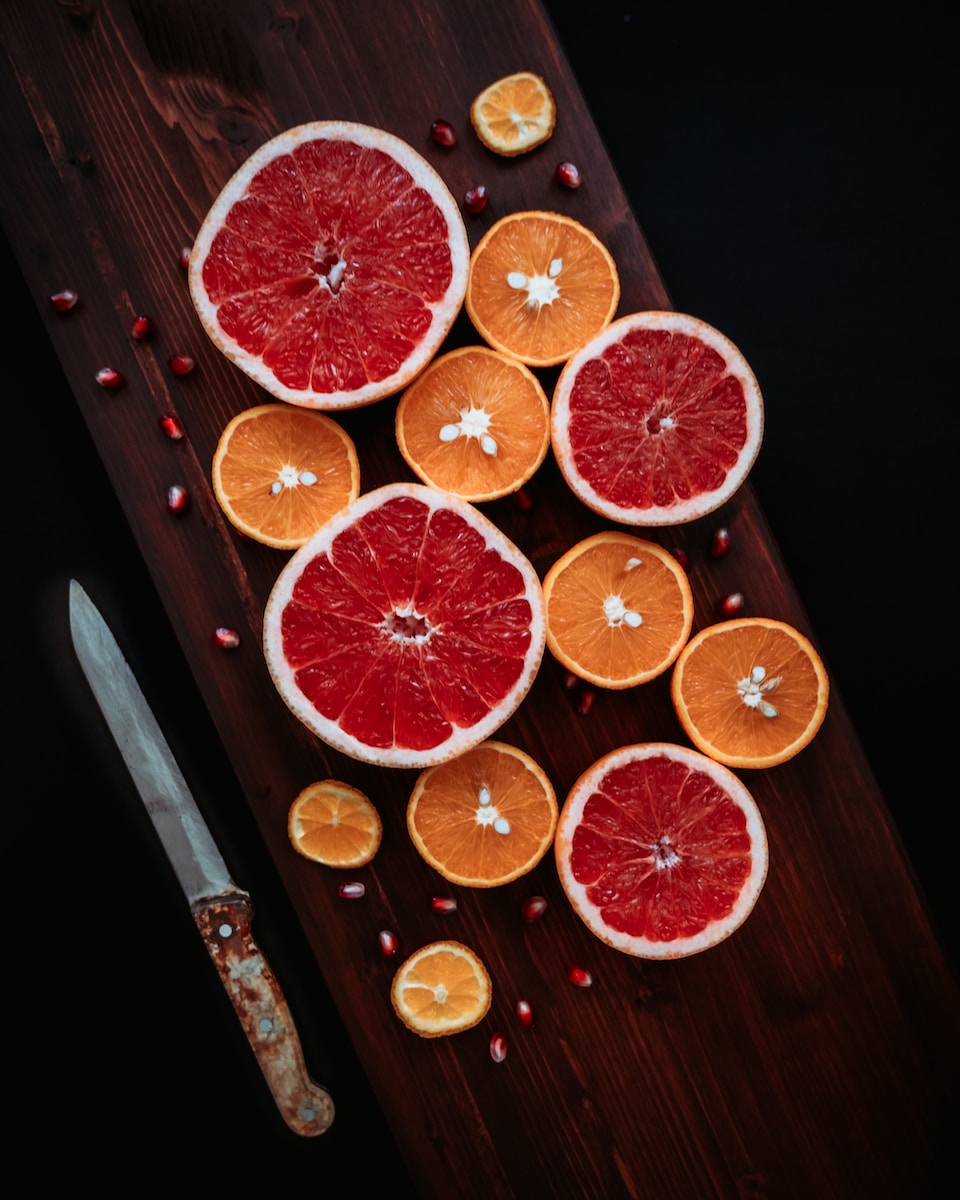 sliced orange fruits on brown wooden chopping board