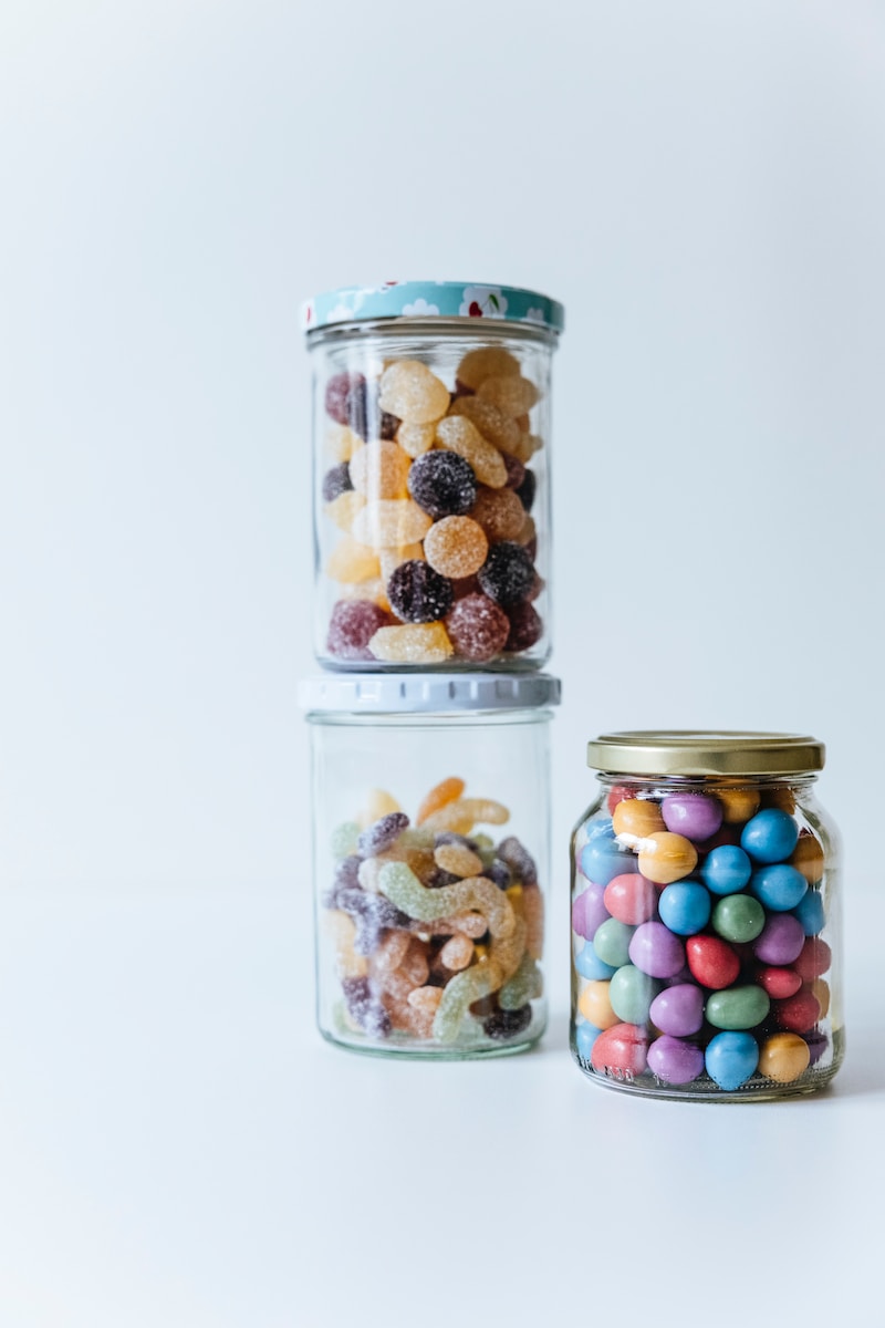 three jars filled with different types of candies