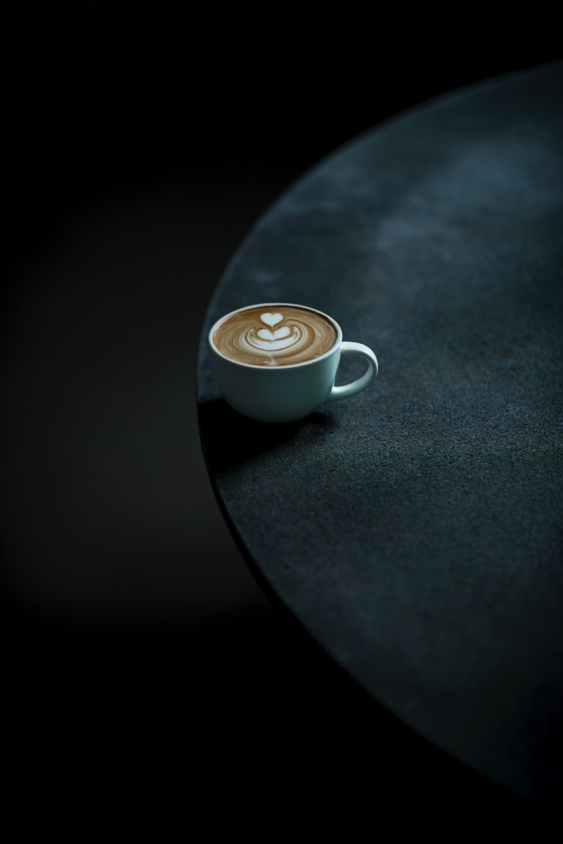 a cappuccino sits on a black table