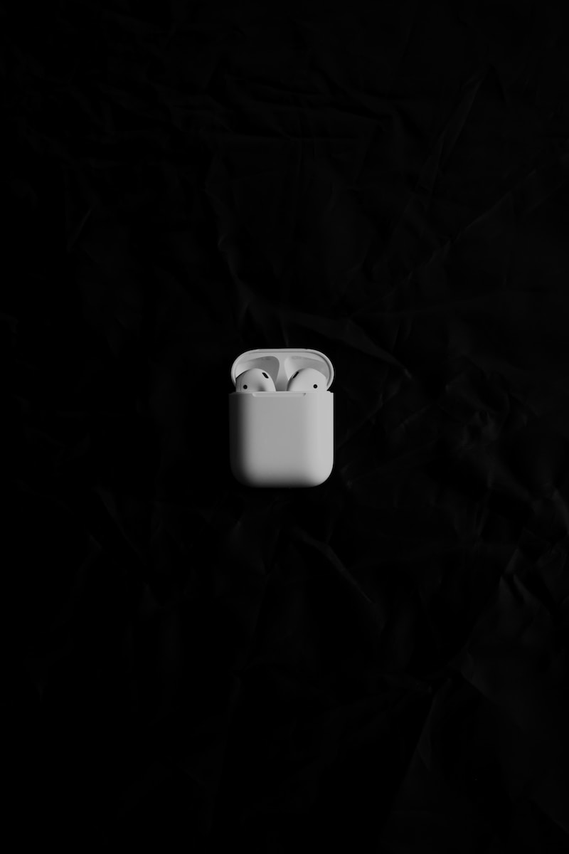 a white apple airpods sitting on top of a black surface