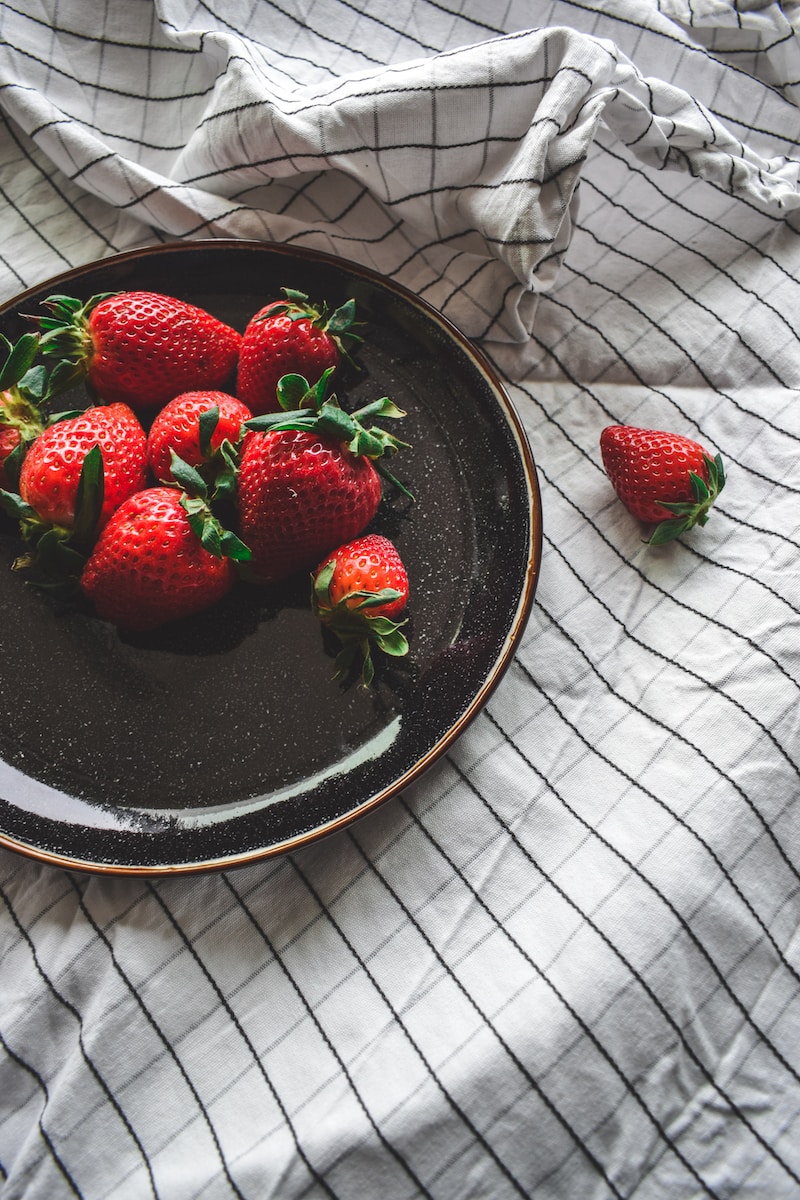 strawberries on black ceramic bowl