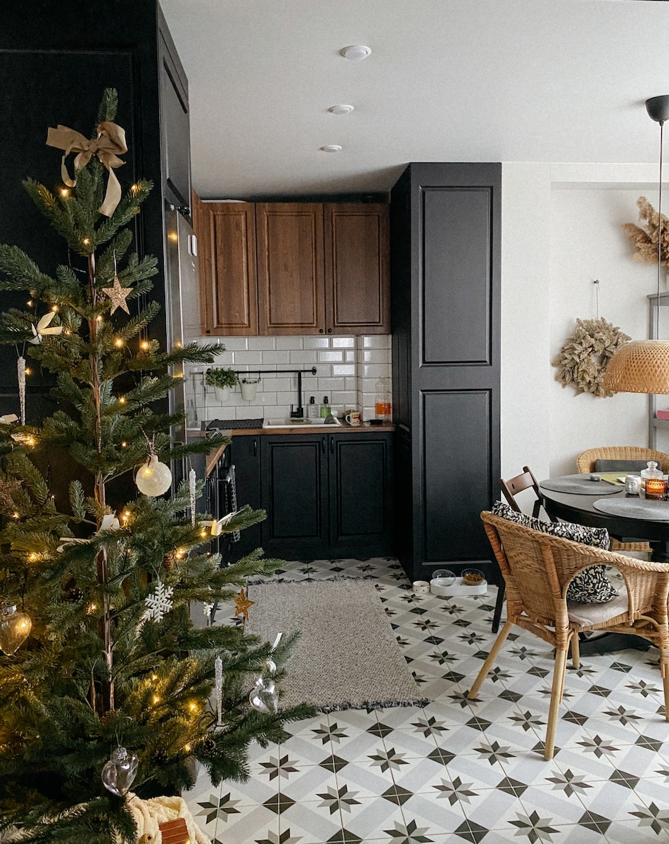 a decorated christmas tree in a kitchen next to a dining room table