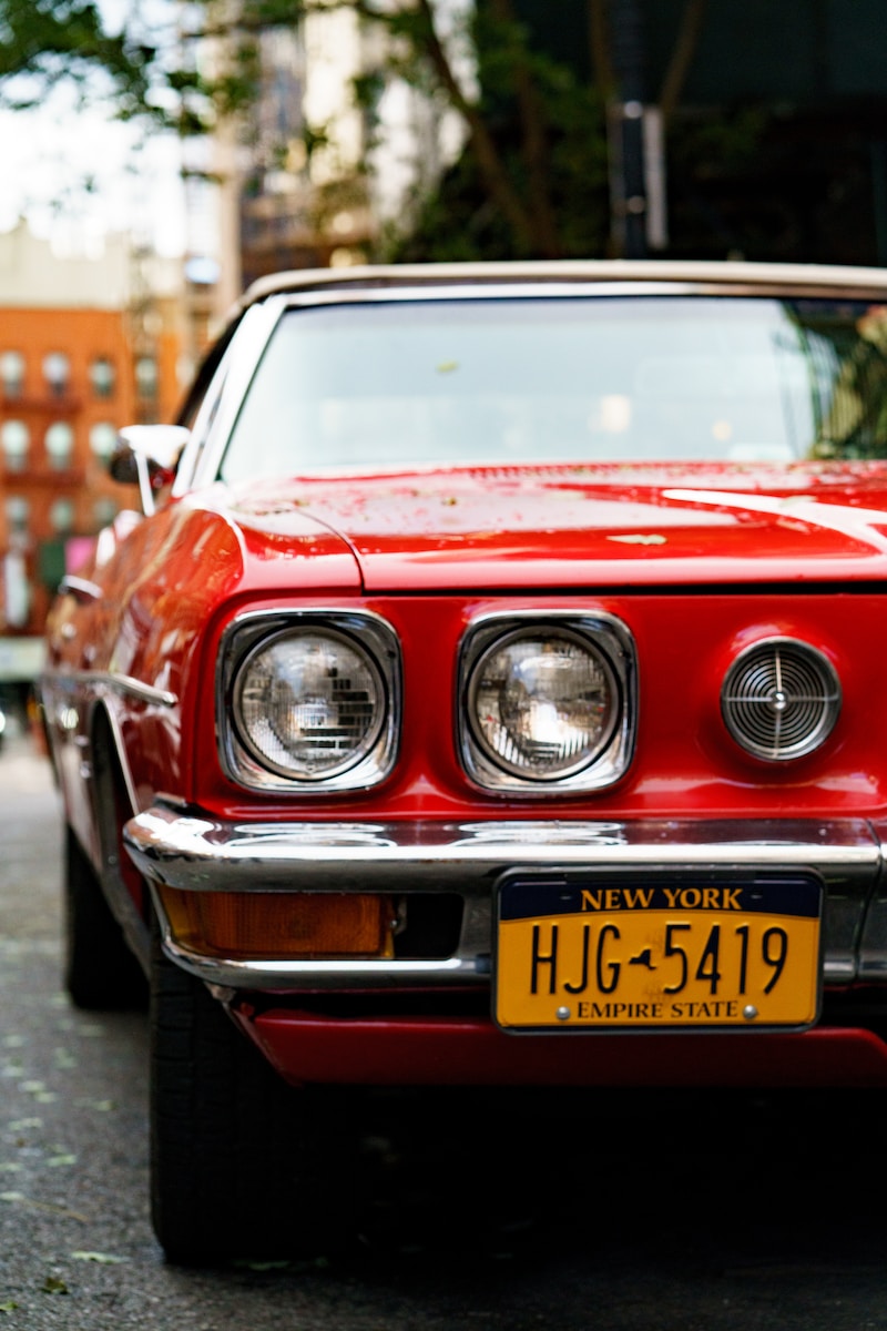 close up photo of red car with New York HJG 5419 license plate
