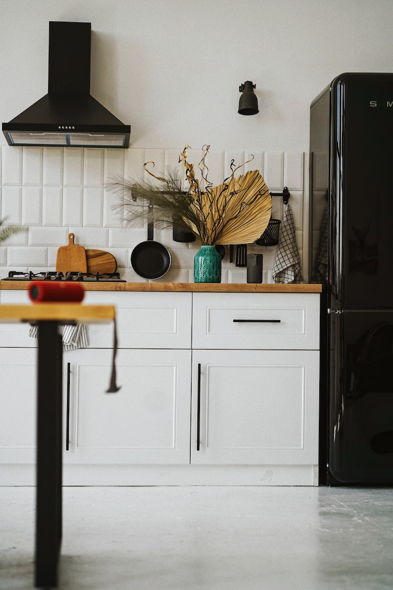 a kitchen with a black refrigerator
