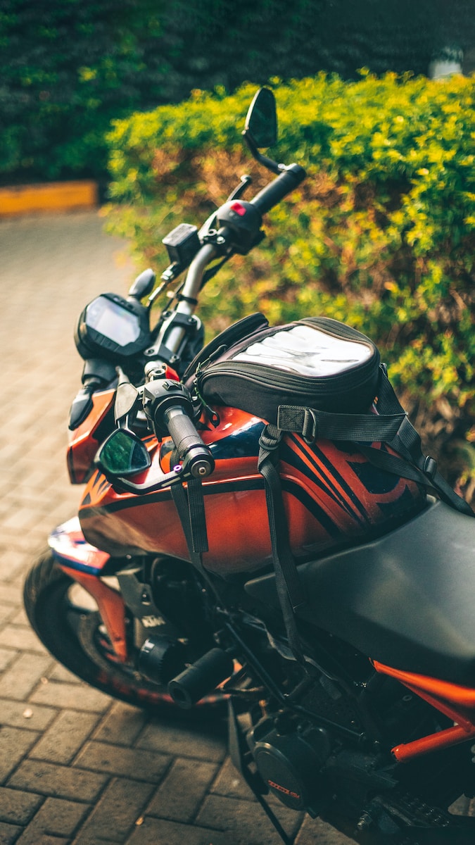a red and black motorcycle parked on a brick road