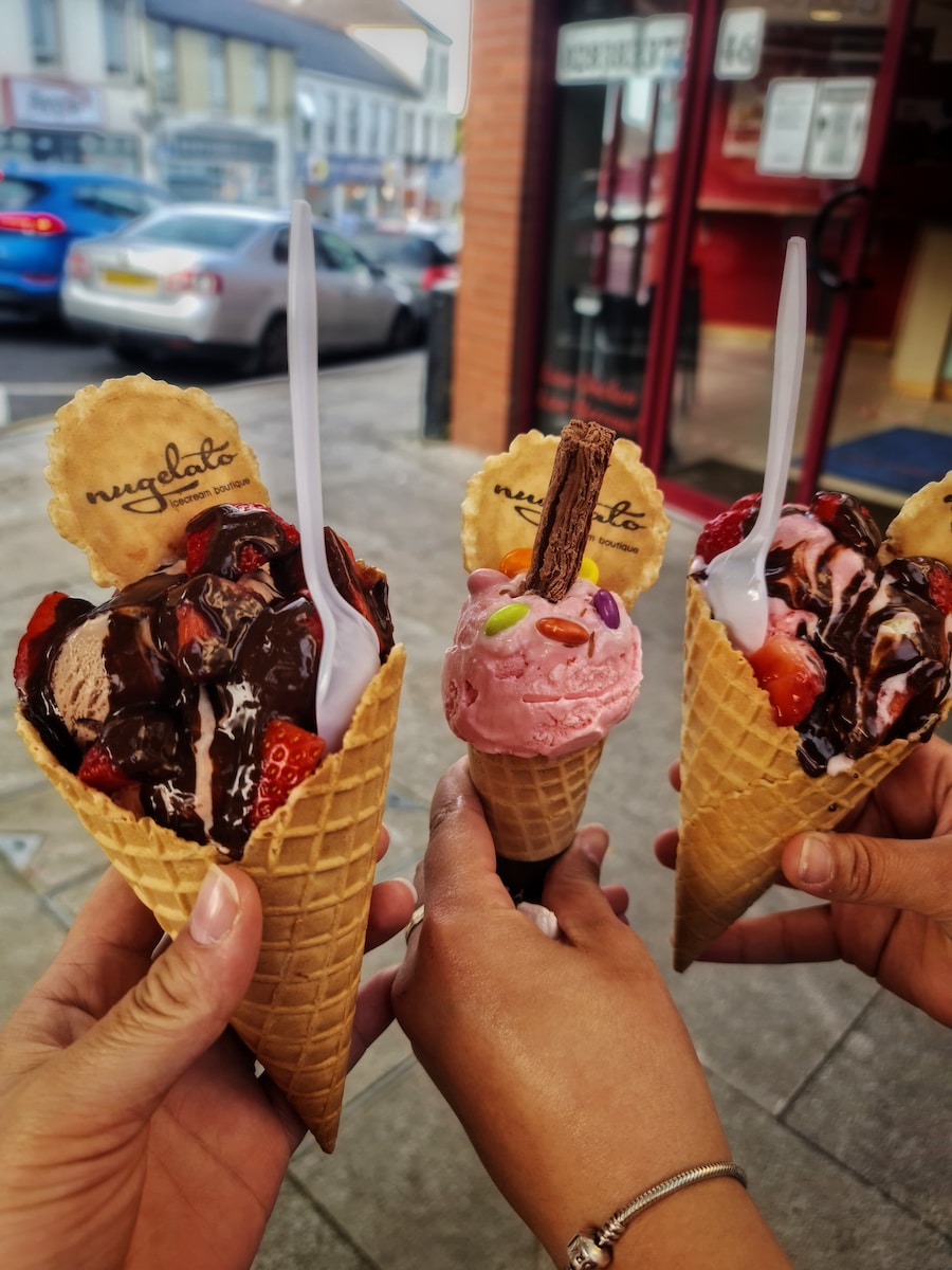 person holding ice cream cone with chocolate ice cream