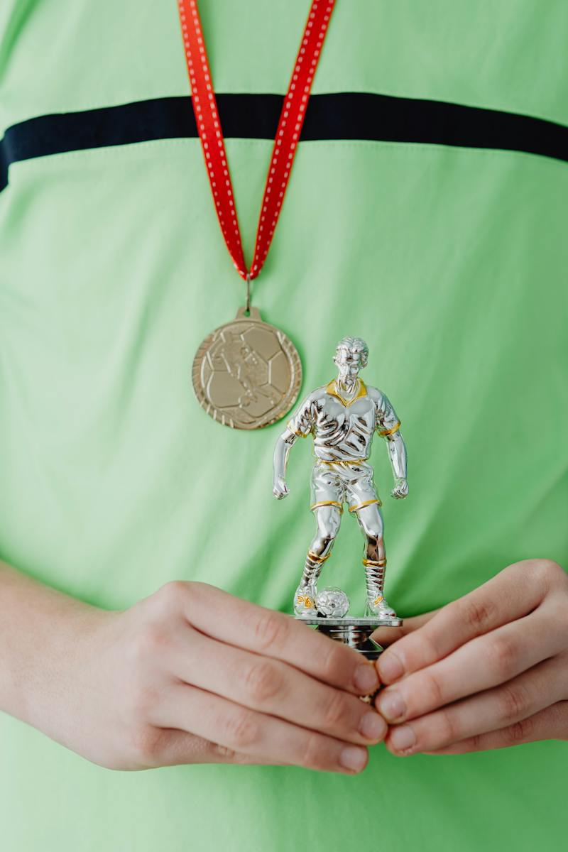 Person with a Medal Holding a Trophy