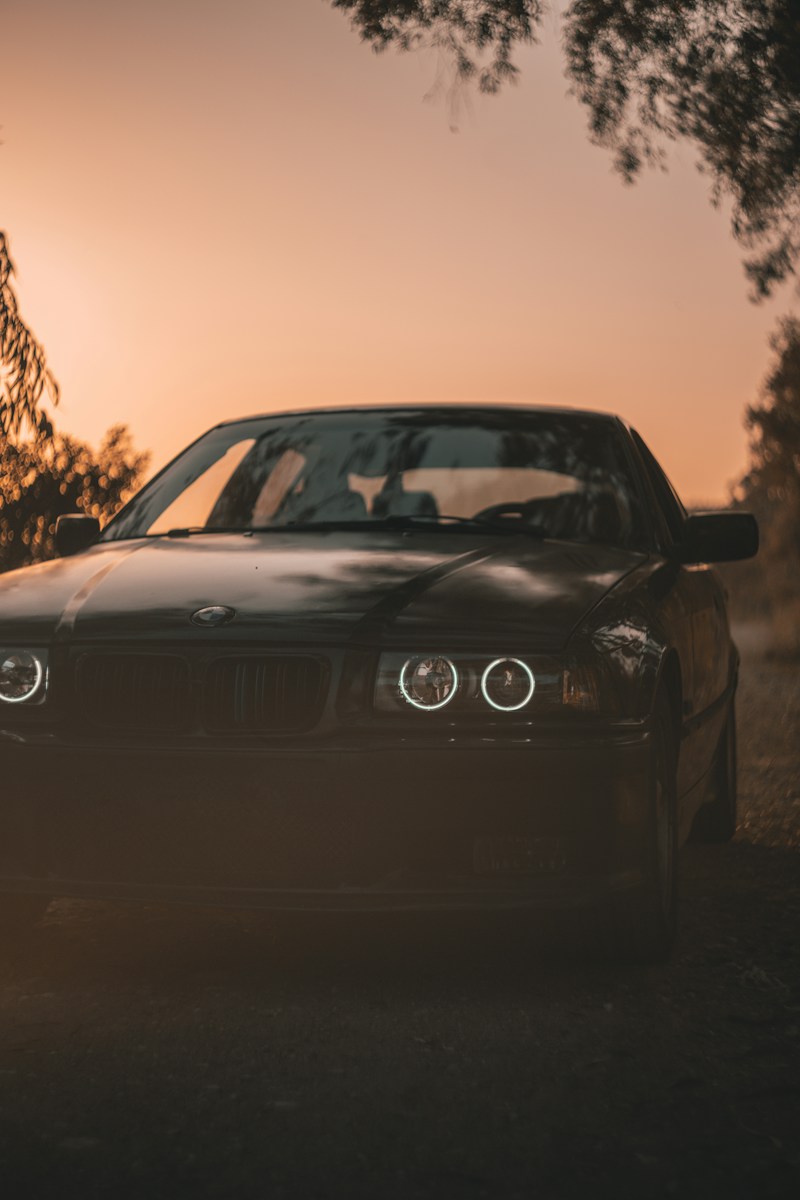 black bmw car on road during sunset