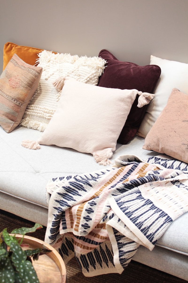 assorted throw pillows on gray couch