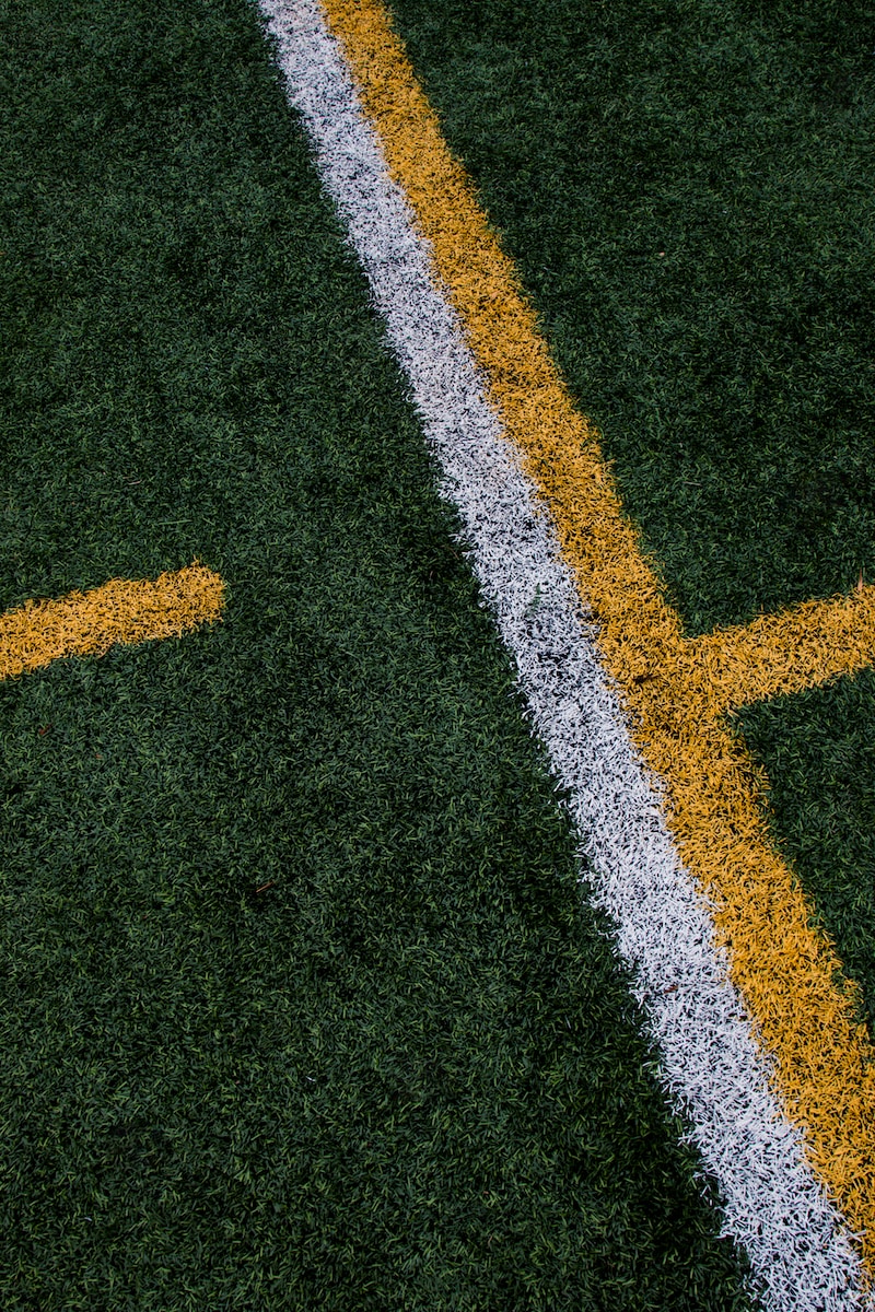 a close up of a yellow and white line on a field