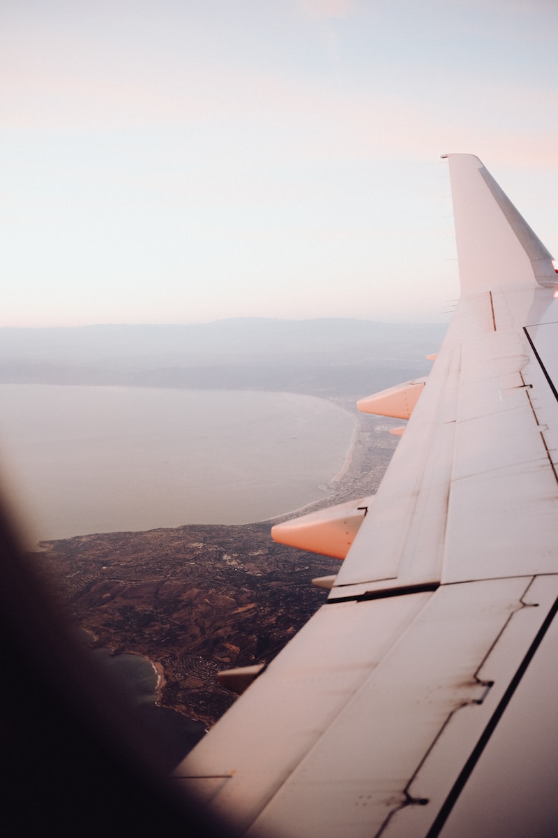 the wing of an airplane flying over a body of water