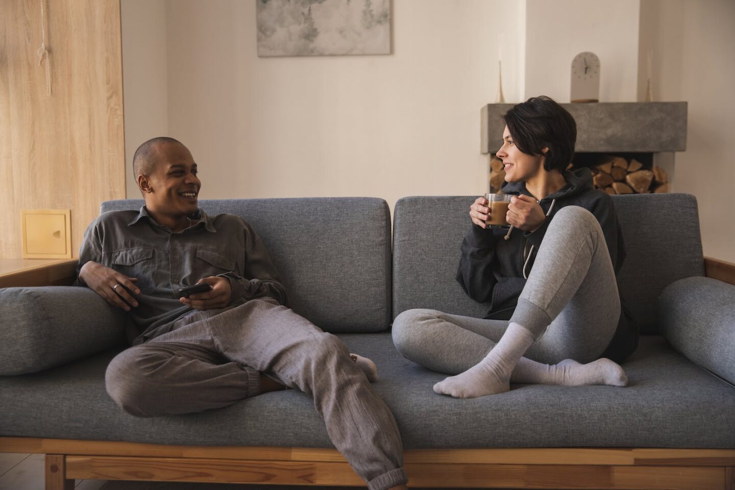 Happy young multiracial couple taking on sofa at home